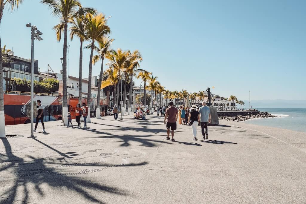 people walking along the malecon next to the water in Puerto Vallarta, Mexico