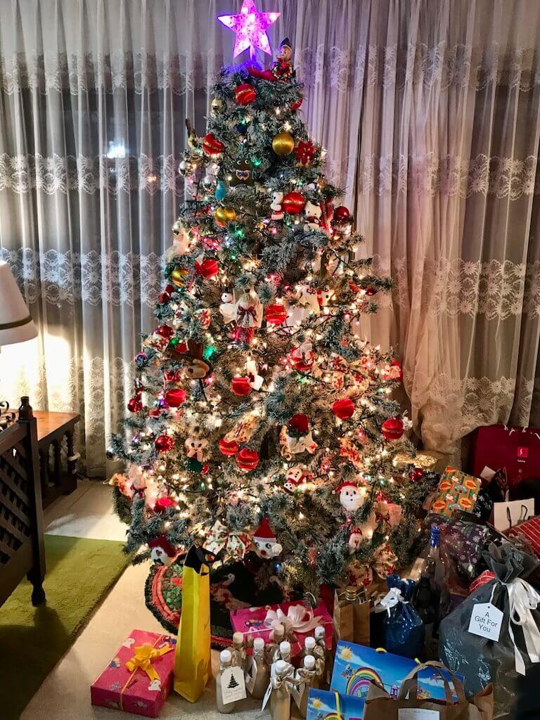 christmas tree decorated with presents underneath it