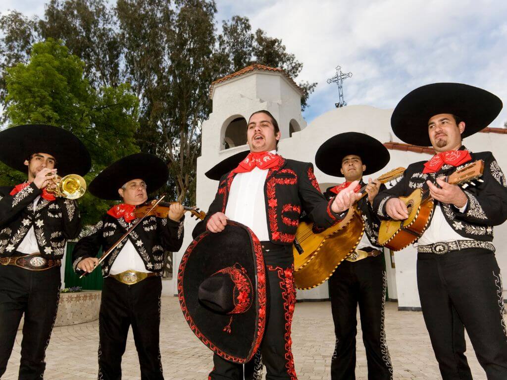 mexican mariachi band standing in front of white church