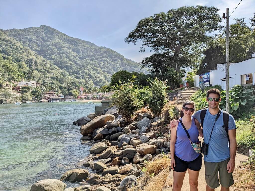 Puerto Vallarta travelers, wearing shorts and t-shirts, posing with the bay of Boca de Tomatlan in the background.