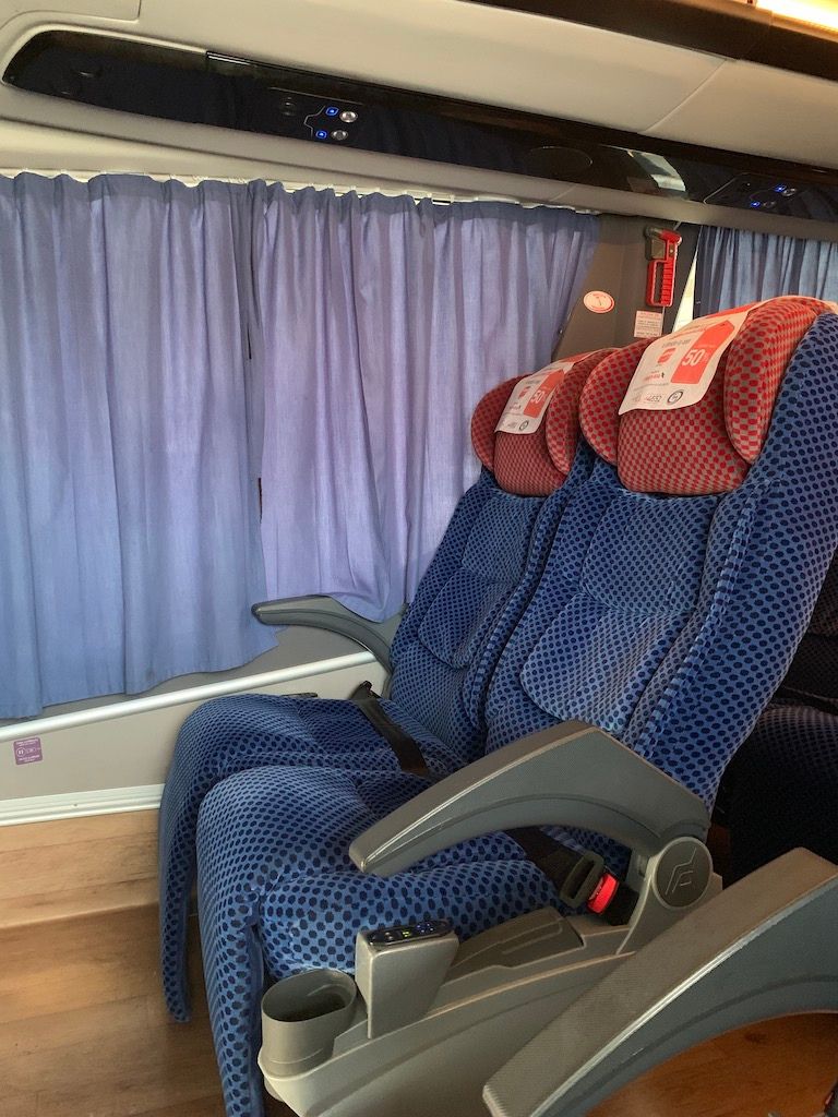 Interior of an ADO bus showing comfortable blue patterned seats, illustrating the comfort level one might experience when taking a bus from Mexico City to Oaxaca.