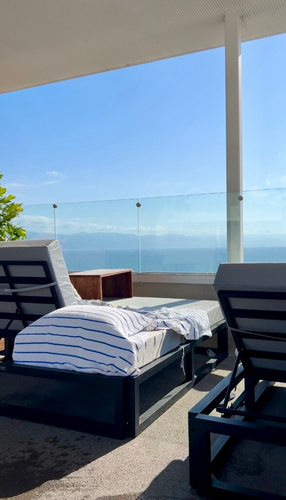 a deck with chairs and a bed