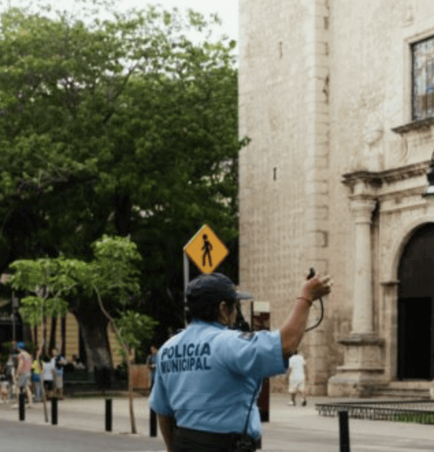 Municipal police officer directing traffic in the early evening in the summer of 2025.