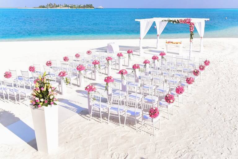 A beach wedding setup with floral decor and ocean views are part of the cost for a destination wedding in mexico.