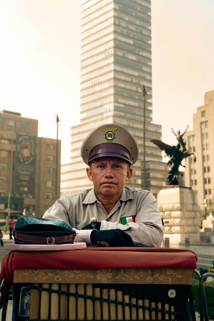 A police officer in uniform sits in front of torre latinoamericana, ciudad de méxico. They are very helpful when it comes to learning how to stay safe in mexico.