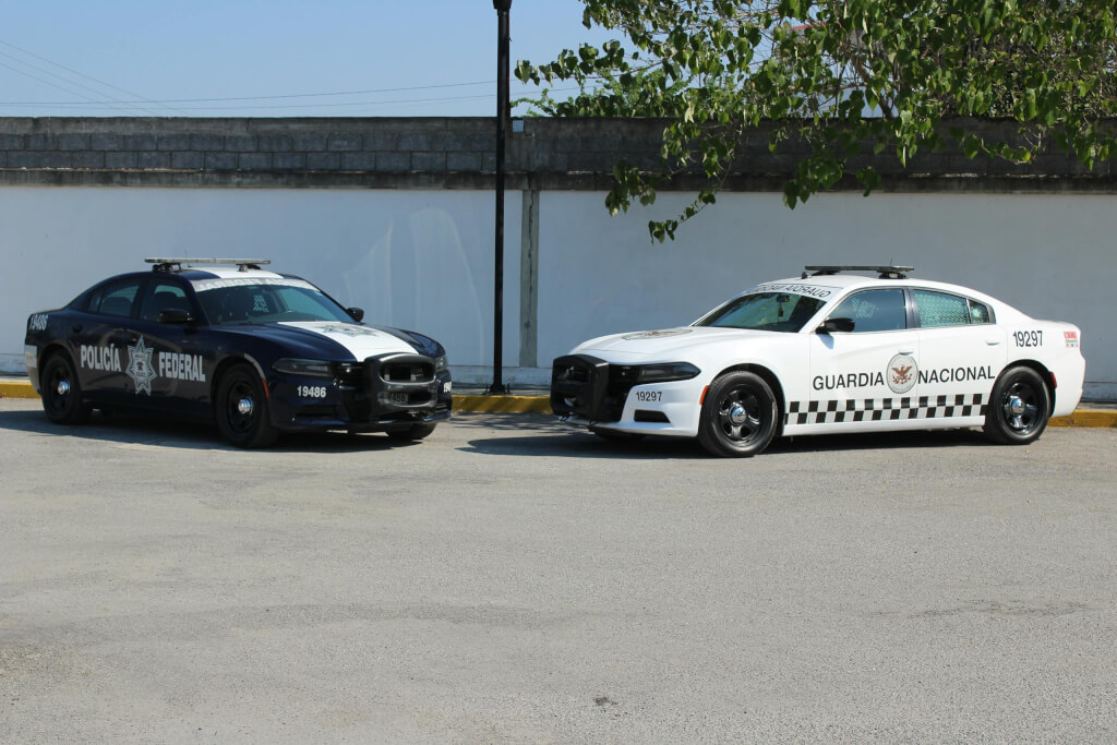 Two service vehicles, policía federal and guardia nacional, parked in an empty lot and help solo female travelers in mexico to stay safe.